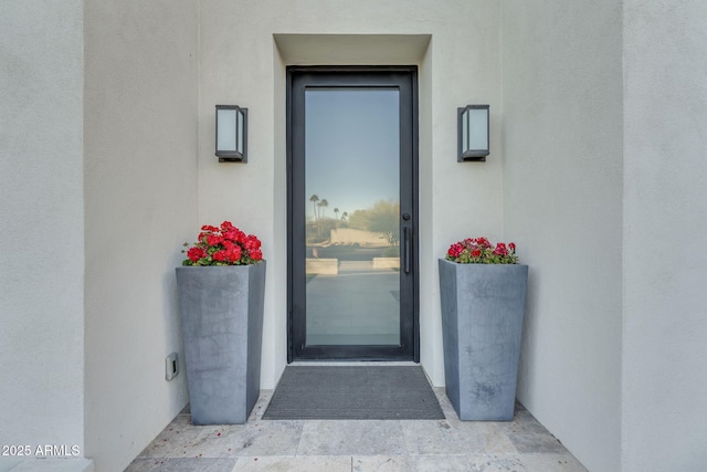 view of exterior entry with stucco siding