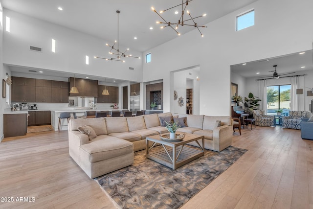 living room with a notable chandelier, visible vents, light wood-style flooring, and recessed lighting