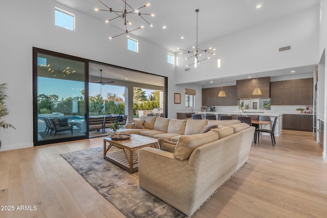 living room with recessed lighting, visible vents, light wood-type flooring, and a chandelier