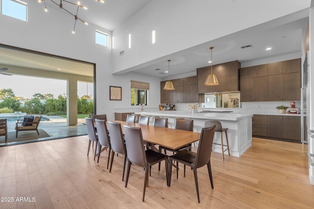 dining room with a wealth of natural light, visible vents, and light wood finished floors