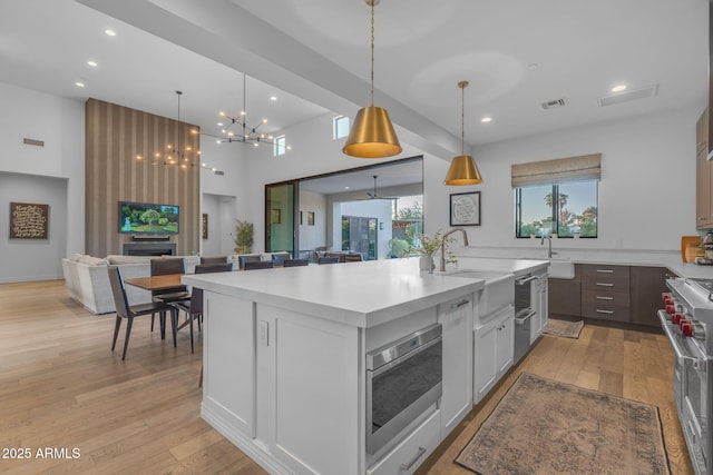 kitchen with a sink, visible vents, light wood-style floors, and appliances with stainless steel finishes