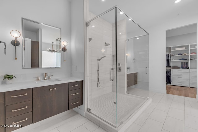 bathroom featuring vanity, a shower stall, a spacious closet, and tile patterned floors