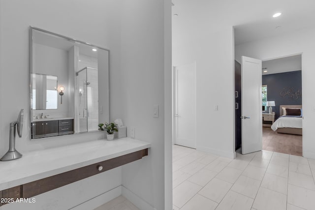 full bathroom with baseboards, recessed lighting, a sink, a shower stall, and connected bathroom