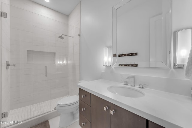 bathroom with vanity, a shower stall, and toilet