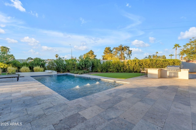 view of pool with a grill, a patio area, a fenced in pool, and an outdoor kitchen