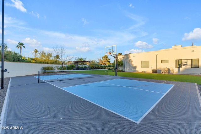 view of tennis court with community basketball court and fence