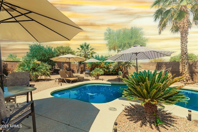 pool at dusk with a fenced in pool, a fenced backyard, and a patio area