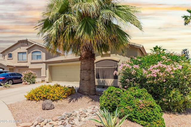 view of front of house with stucco siding, driveway, and a garage