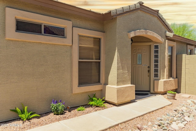 property entrance with stucco siding