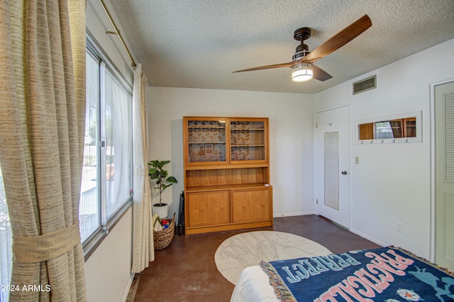 bedroom with a textured ceiling and ceiling fan