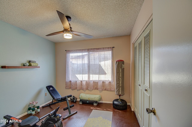 exercise room with a textured ceiling, wood-type flooring, and ceiling fan