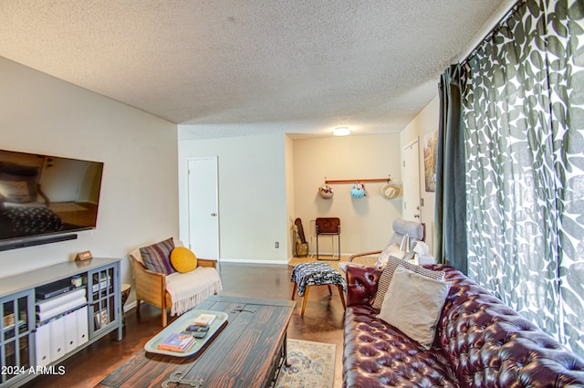 living room with a textured ceiling and dark hardwood / wood-style floors