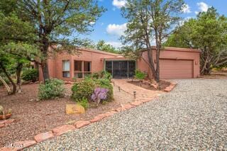 25 Edgewood Cir, Sedona, AZ 86336 - view of front of house featuring driveway, a garage, and stucco siding