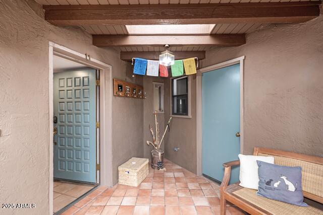 25 Edgewood Cir, Sedona, AZ 86336 - interior space with a textured wall and beamed ceiling