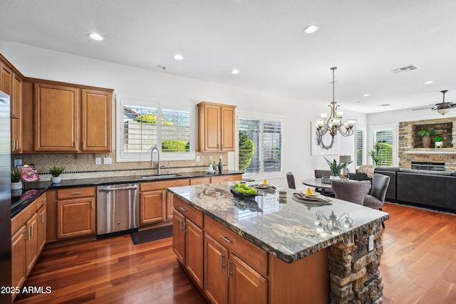 2207 W Hidden Treasure Way, Phoenix, AZ 85086 - kitchen with stainless steel dishwasher, dark wood-style flooring, decorative backsplash, a fireplace, and recessed lighting