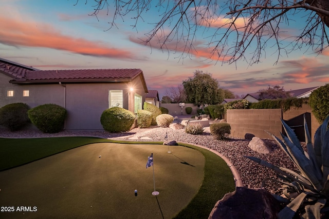 2207 W Hidden Treasure Way, Phoenix, AZ 85086 - yard at dusk with an area to practice putting