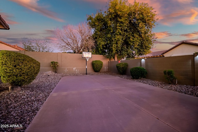 2207 W Hidden Treasure Way, Phoenix, AZ 85086 - patio terrace at dusk featuring a fenced backyard and basketball hoop