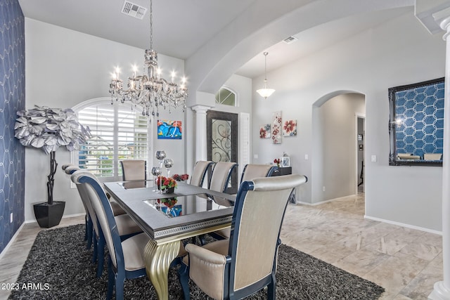 dining space with an inviting chandelier, light tile flooring, and ornate columns