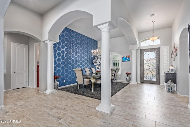 entrance foyer featuring ornate columns and light tile flooring