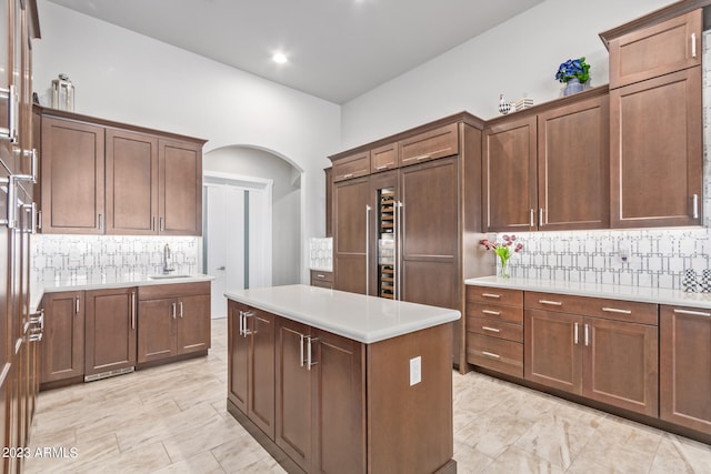 kitchen featuring light tile floors, sink, a center island, and tasteful backsplash