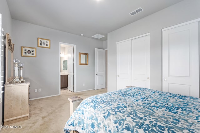 carpeted bedroom with ensuite bathroom and two closets