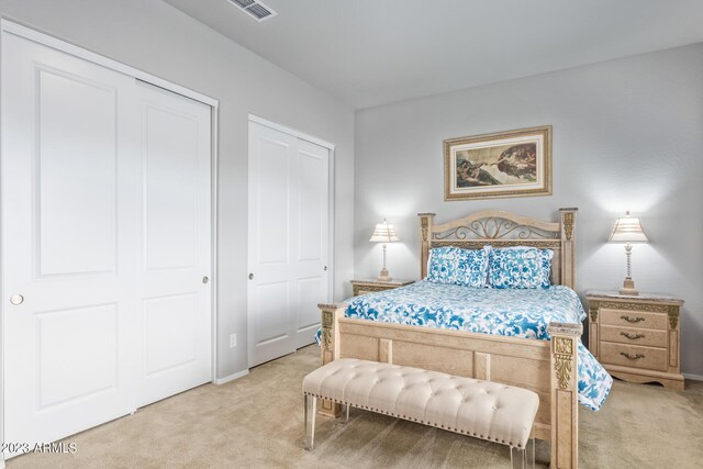 carpeted bedroom featuring multiple closets