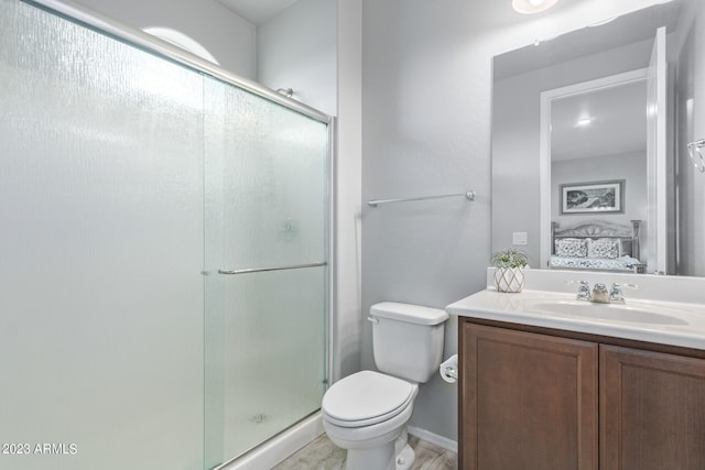 bathroom featuring toilet, vanity, and a shower with shower door