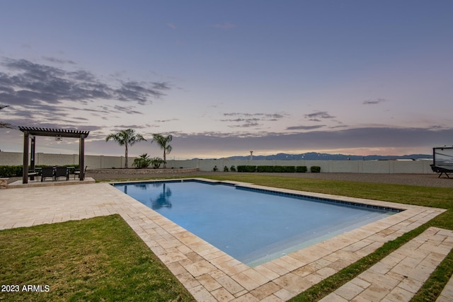 pool at dusk featuring a yard and a patio