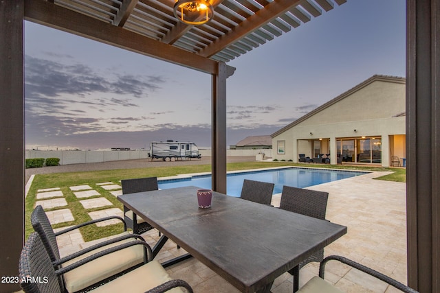 pool at dusk with a pergola, a lawn, and a patio area