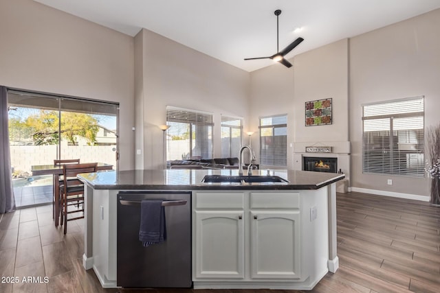 kitchen with ceiling fan, dishwasher, high vaulted ceiling, white cabinets, and sink