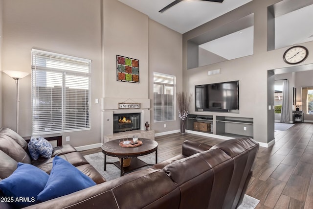 living room with ceiling fan and a high ceiling