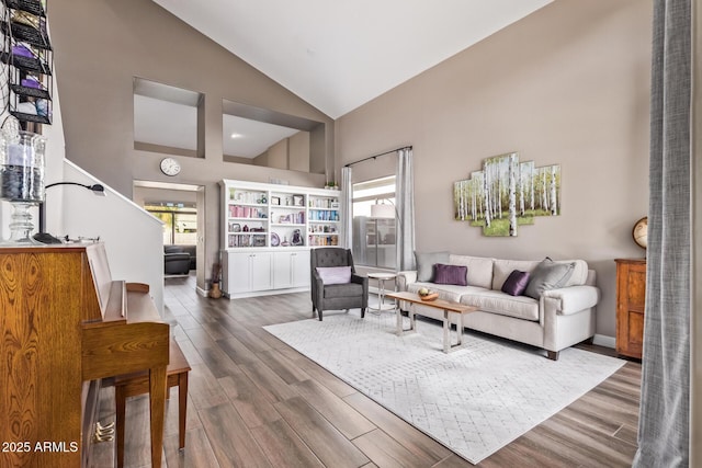 living room featuring dark wood-type flooring, plenty of natural light, and high vaulted ceiling