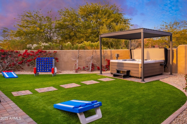 yard at dusk featuring a hot tub