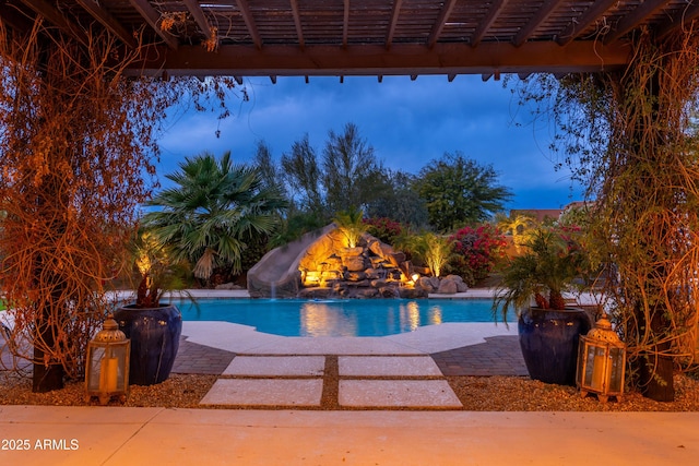 pool at dusk featuring a patio and a water slide