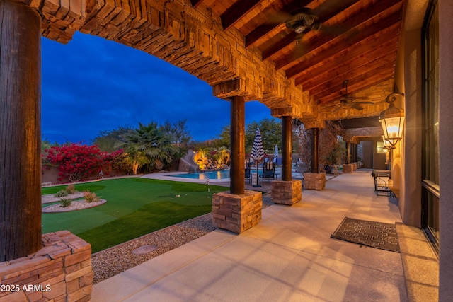 patio terrace at dusk featuring ceiling fan