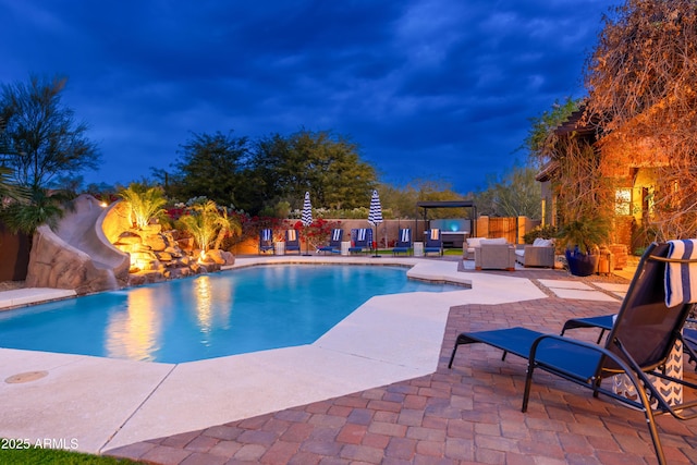 view of pool featuring outdoor lounge area, a patio, and a water slide