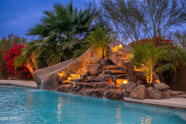 pool at dusk with pool water feature