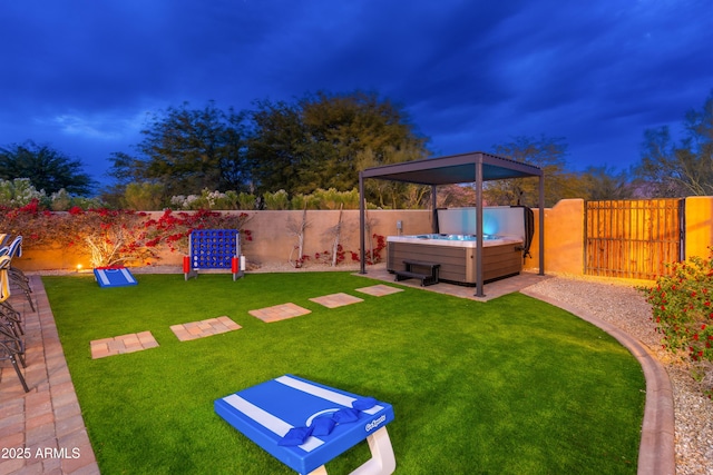 yard at dusk featuring a hot tub