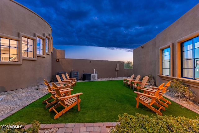 yard at dusk featuring cooling unit