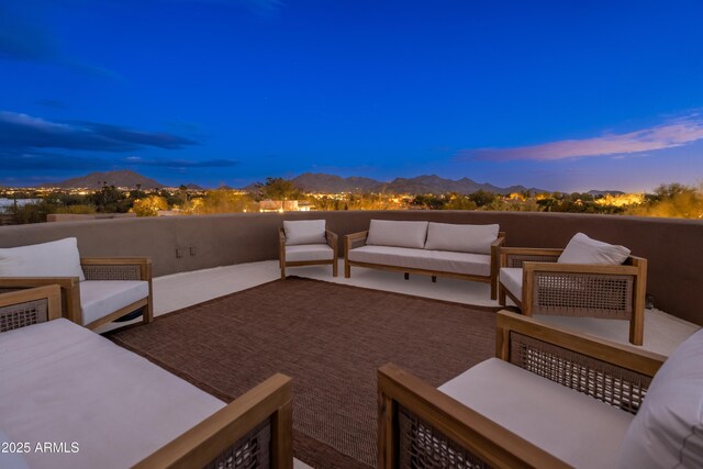 patio terrace at dusk featuring an outdoor living space and a mountain view