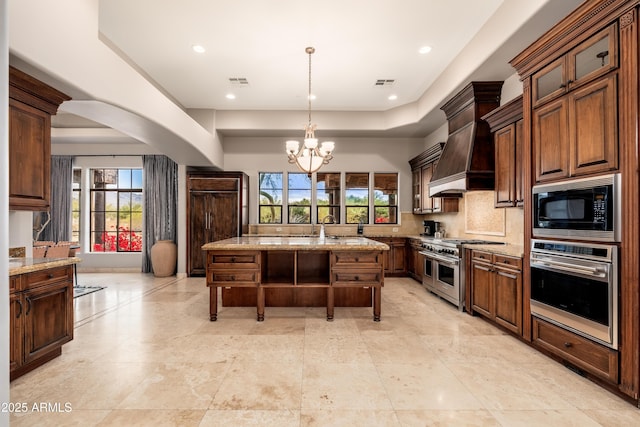 kitchen featuring appliances with stainless steel finishes, backsplash, a center island, light stone counters, and custom exhaust hood