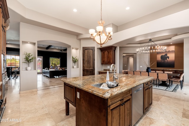 kitchen featuring sink, hanging light fixtures, stainless steel dishwasher, a center island with sink, and an inviting chandelier