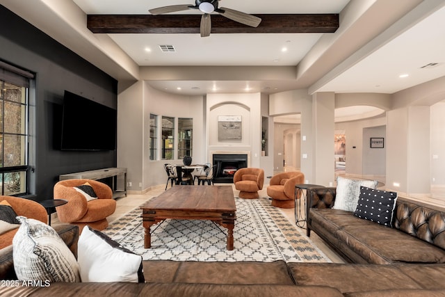 living room featuring beamed ceiling and ceiling fan