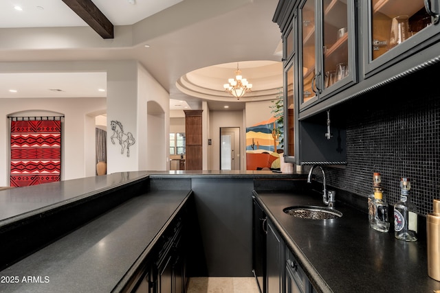 bar with sink, tasteful backsplash, an inviting chandelier, pendant lighting, and beam ceiling