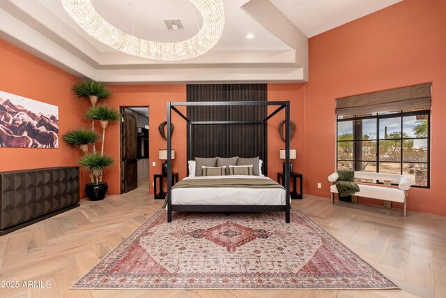 bedroom featuring parquet flooring and a tray ceiling