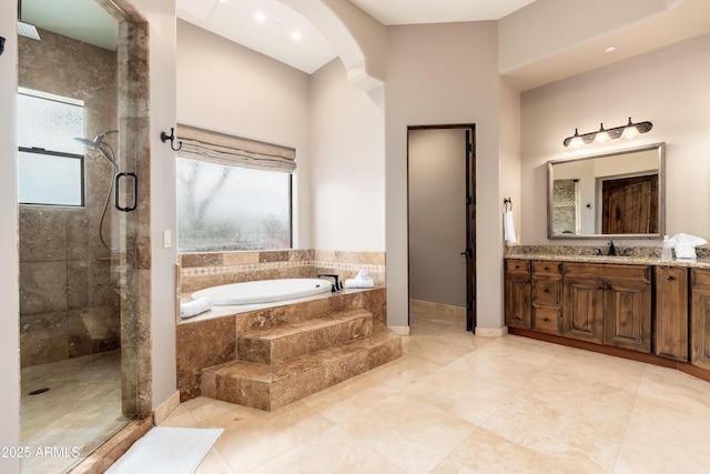 bathroom with vanity, plus walk in shower, and a healthy amount of sunlight