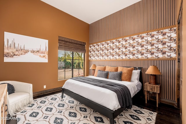 bedroom with wood-type flooring and vaulted ceiling