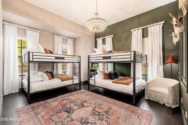 bedroom with dark hardwood / wood-style floors and an inviting chandelier