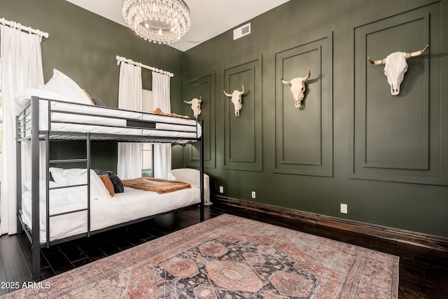 bedroom with dark hardwood / wood-style flooring and a notable chandelier