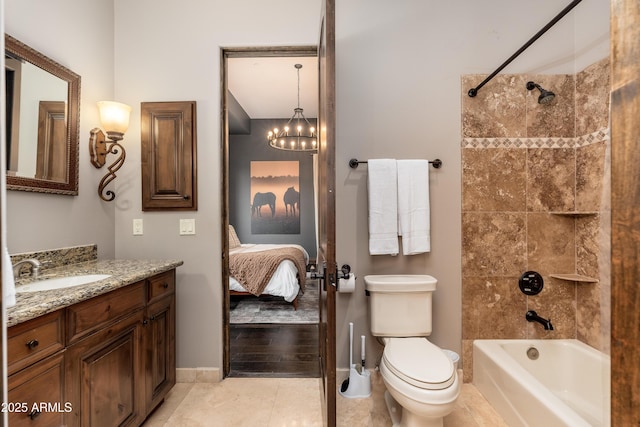 full bathroom with vanity, a notable chandelier, tiled shower / bath, tile patterned floors, and toilet